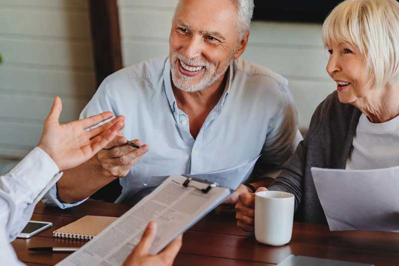 elderly couple sitting at a table while meeting with tax expert